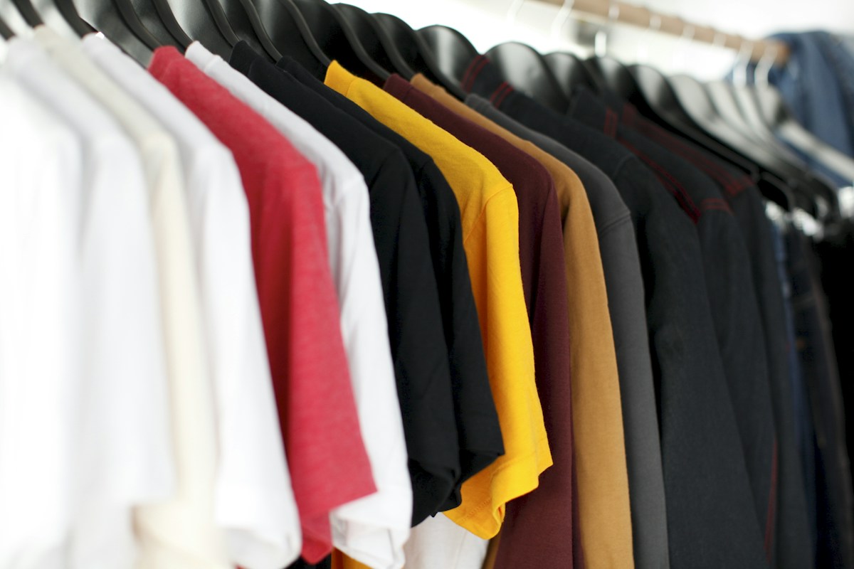 A clothing rail with a variety of colours and styles